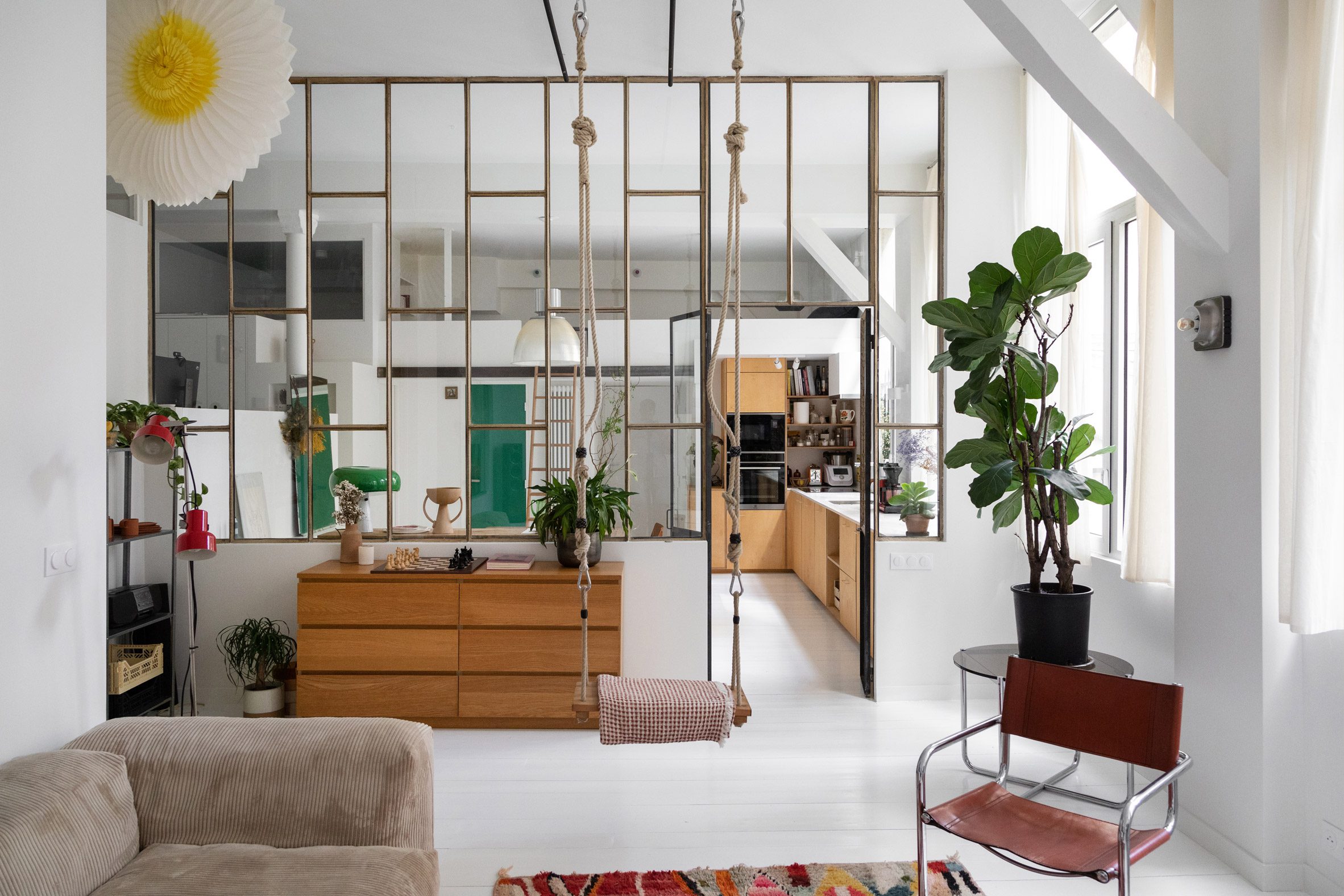 Living room in a high-ceilinged apartment with a swing hanging in it